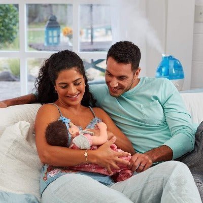 Papa y mama con bebe y humidificador en segundo plano. Para toda la familia